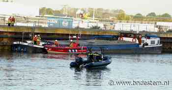 Vrachtschip botst op Amertakbrug en begint te zinken, brandweer controleert boot bij Geertruidenberg