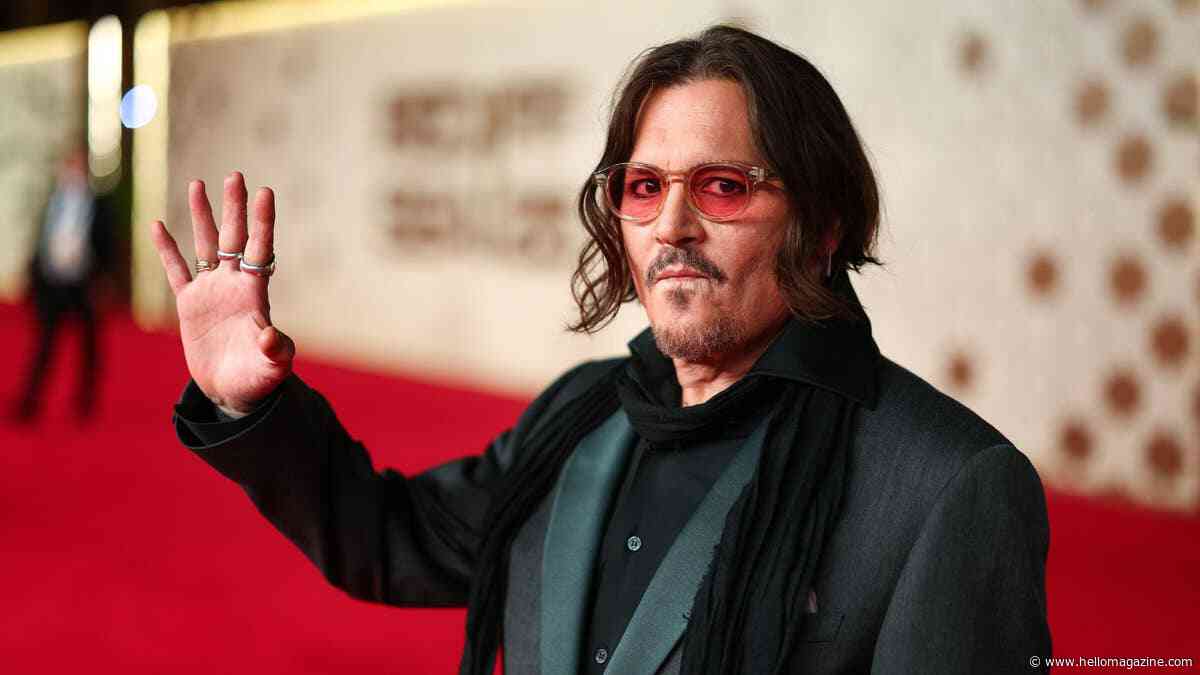 Johnny Depp's Las Vegas photo call takes an unexpected turn as he bites into the backdrop