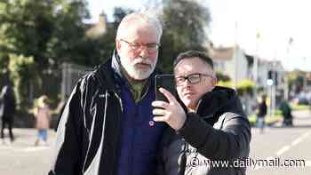 Gerry Adams arrives at Orange Order march after DUP accuses his ex-party Sinn Fein of 'breaking the law' by joining blockade - as protester hurls bottle at police car
