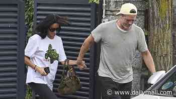 Brad Pitt leads Ines de Ramon by the hand as they leave Madrid following loved-up display at film festival