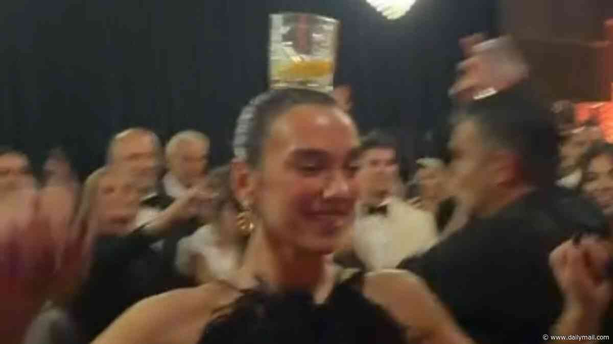 Dua Lipa is hailed an 'Albanian queen' as she perfectly balances a glass on her head while performing a traditional dance with her dad at a family wedding in Prishtina