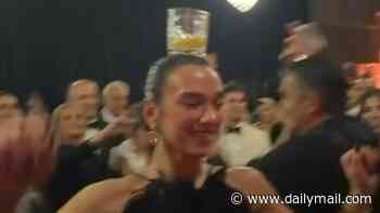 Dua Lipa is hailed an 'Albanian queen' as she perfectly balances a glass on her head while performing a traditional dance with her dad at a family wedding in Prishtina