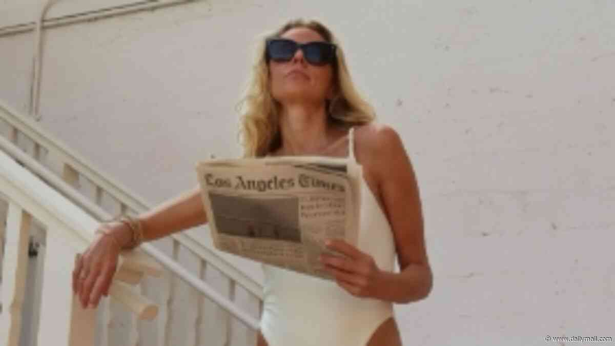 Donna Air, 47, shows off her incredible figure in a white swimsuit as she catches up on the news while kicking back poolside in Los Angeles