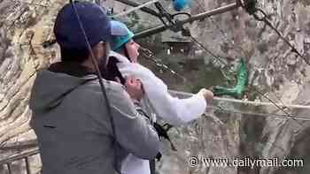 Moment terrified female tourist is forced into 260ft canyon leap by staff who kick her legs in front of laughing husband - as video sparks probe