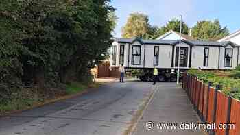 Moment police cause outrage by 'escorting' a static caravan on to an illegal site where travellers paved over a village's protected field