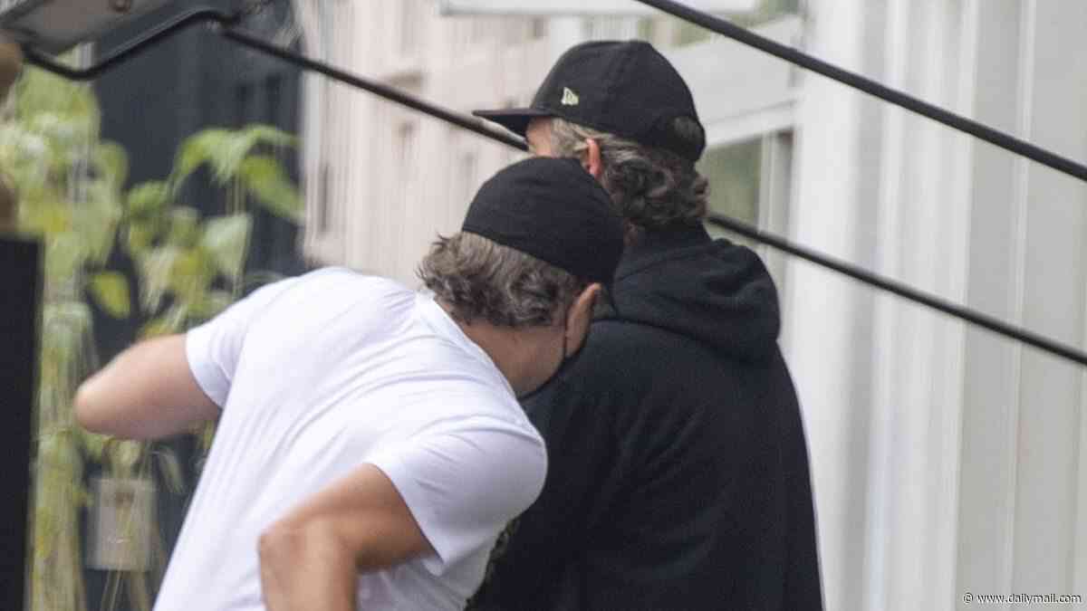 Leonardo DiCaprio tries out his boxing moves as he play fights with a friend while going unnoticed on a day out with his dad and stepmum in Notting Hill