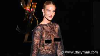 Rosie Huntington-Whiteley stuns in her most daring look to date as she pushes boundaries in a sheer lace dress at the Saint Laurent Paris Fashion Week show