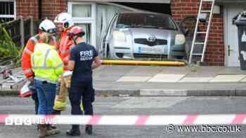 Woman in hospital after car crashes into house