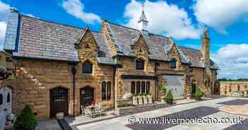 Inside converted 150-year-old coach house with suit of armor on the stairs