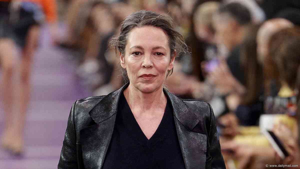 Olivia Colman ties back her new long grey hair as she walks the runway alongside ab-flashing Gigi Hadid at Paris Fashion Week's Miu Miu show