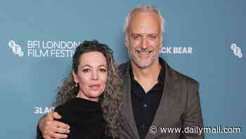 Olivia Colman, 52, shows off her new long grey hair as husband Ed Sinclair puts his arms around her at the Wicker premiere at London's Film Festival