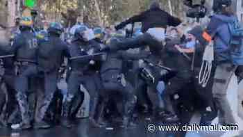 Moment French riot police violently clash with students in central Paris - as Muslim far-Left mayor at the forefront of protests poses with fans for selfies