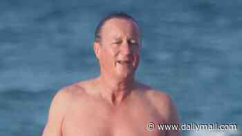 David Cameron makes a splash as he enjoys cold plunge at the beach with friends to mark the start of his 60th birthday celebrations