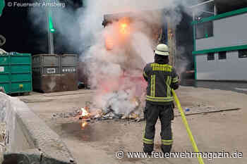 Feuerwehr zieht brennenden Container aus Anlieferungshalle