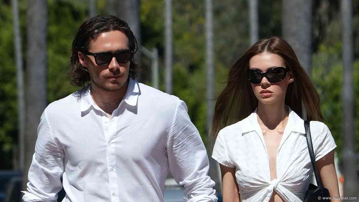 Nicola Peltz flashes her abs in a tie-up top as she and Brooklyn Beckham twin in matching jeans and shirts