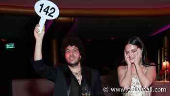 Selena Gomez looks embarrassed by Benny Blanco at celebrity auction... after marking first wedding anniversary