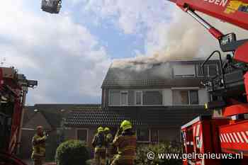 Vlammen slaan uit dak bij woningbrand