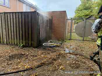 OV-fiets in brand, vlammen slaan over op schutting