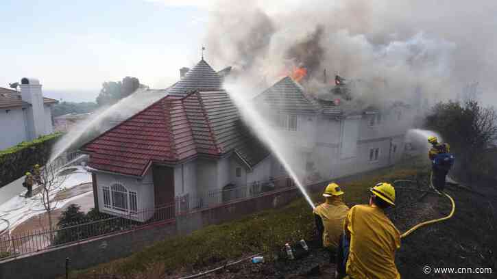 Fast-moving Southern California wildfire burns homes and forces thousands to flee