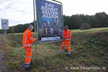 Auf Plakaten im Vogtland schwingt das Wildschwein die Keule für mehr Verkehrssicherheit