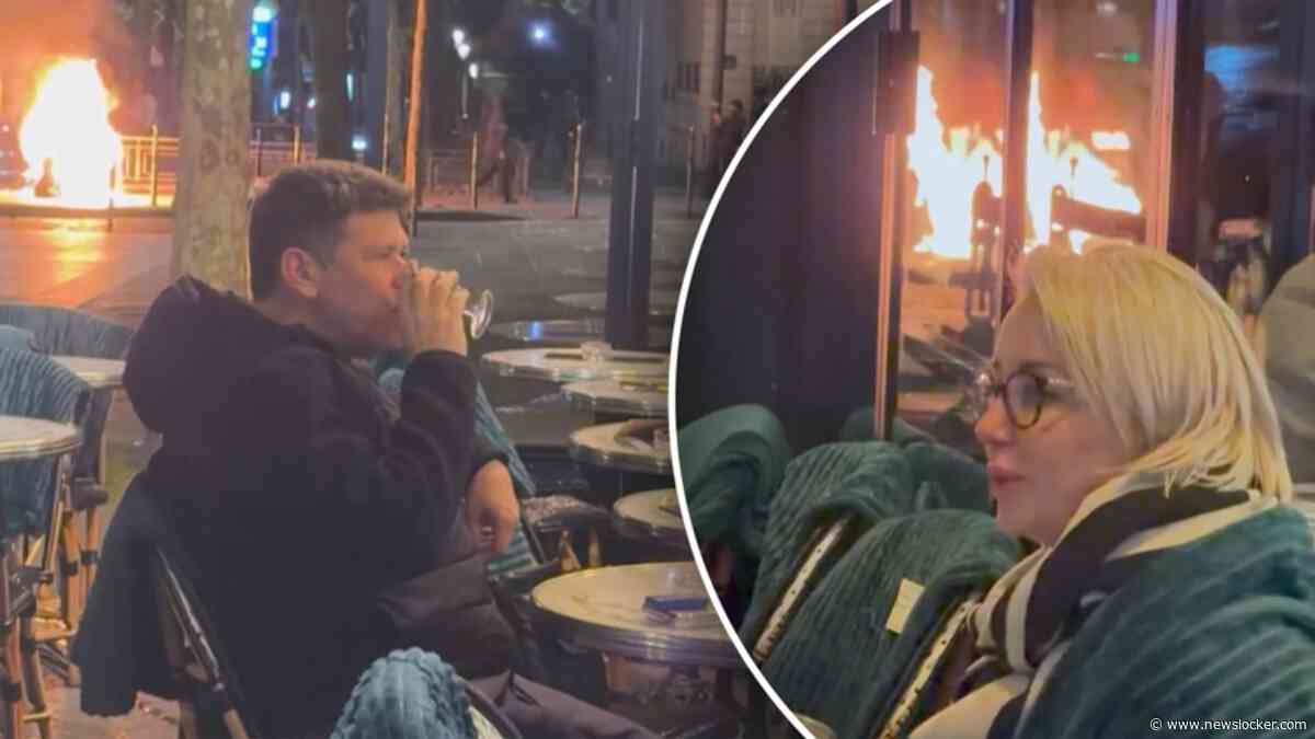 Koppel geniet van drankje alsof er niets aan de hand is tijdens Franse rellen