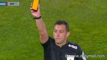 Now even RED CARDS go digital! Referee uses a 'smartphone' to dish out his punishments - but fans are not convinced