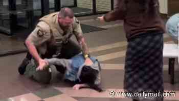 Utah woman hurled to the ground after protesting data center at public meeting denies kicking deputy in the groin... and says she feared for her teeth during tussle