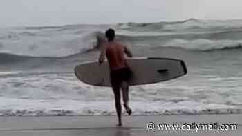 Moment off-duty RNLI lifeguard strips to his PANTS to save a swimmer struggling in the sea in Storm Boelo