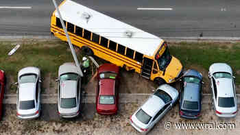 School bus carrying 30 students crashes into Durham car dealership, damaging vehicles
