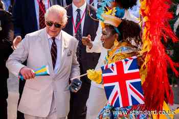 Charles shakes maracas and joins dancers in carnival parade